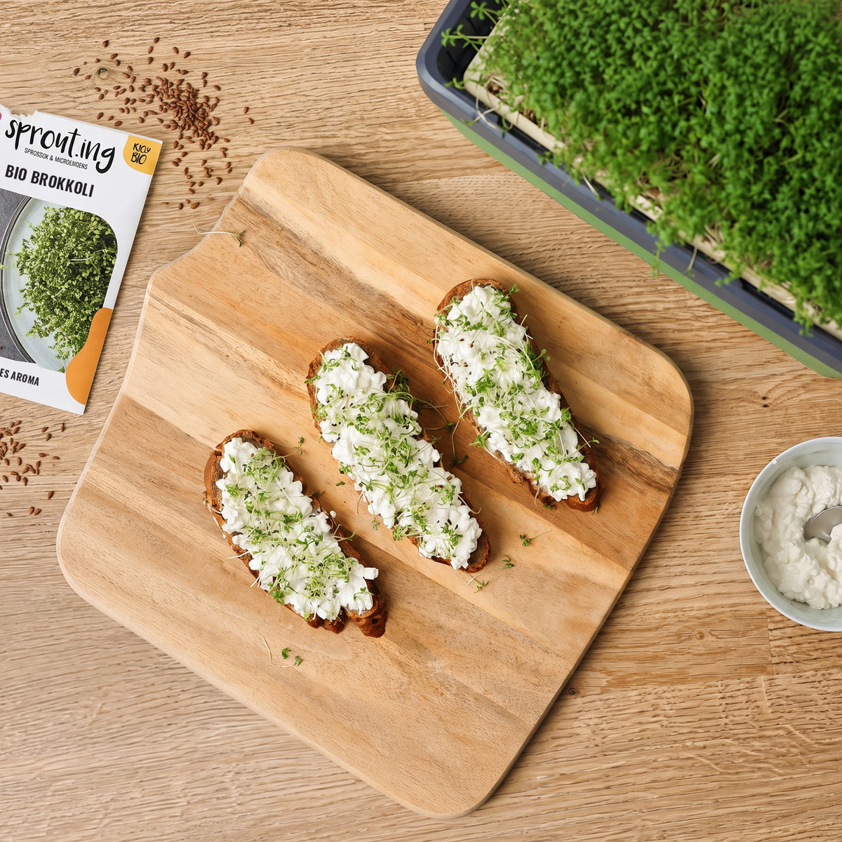 Frisch geschnittene Microgreens auf Brot, daneben HARRY HERBS und sprout.ing Tüten